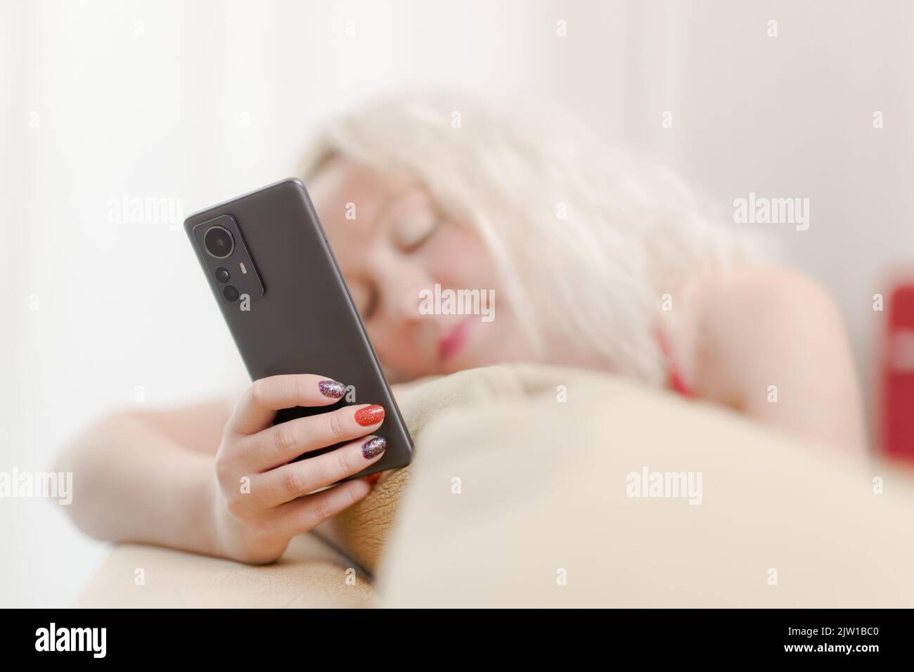 Blond woman work on mobile from home Stock Photo
