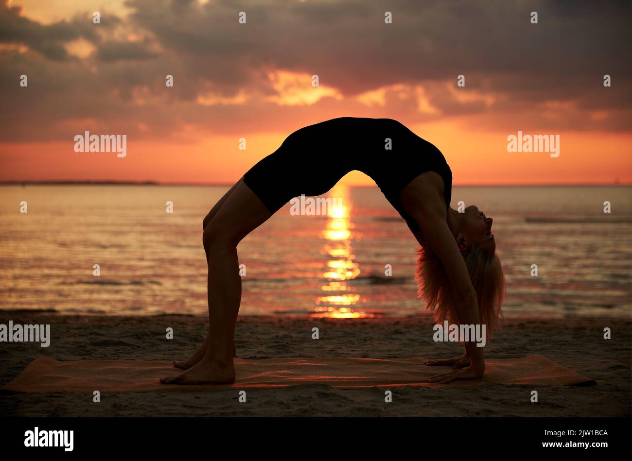 One legged wheel yoga pose on the beach stock photo (235590) -  YouWorkForThem