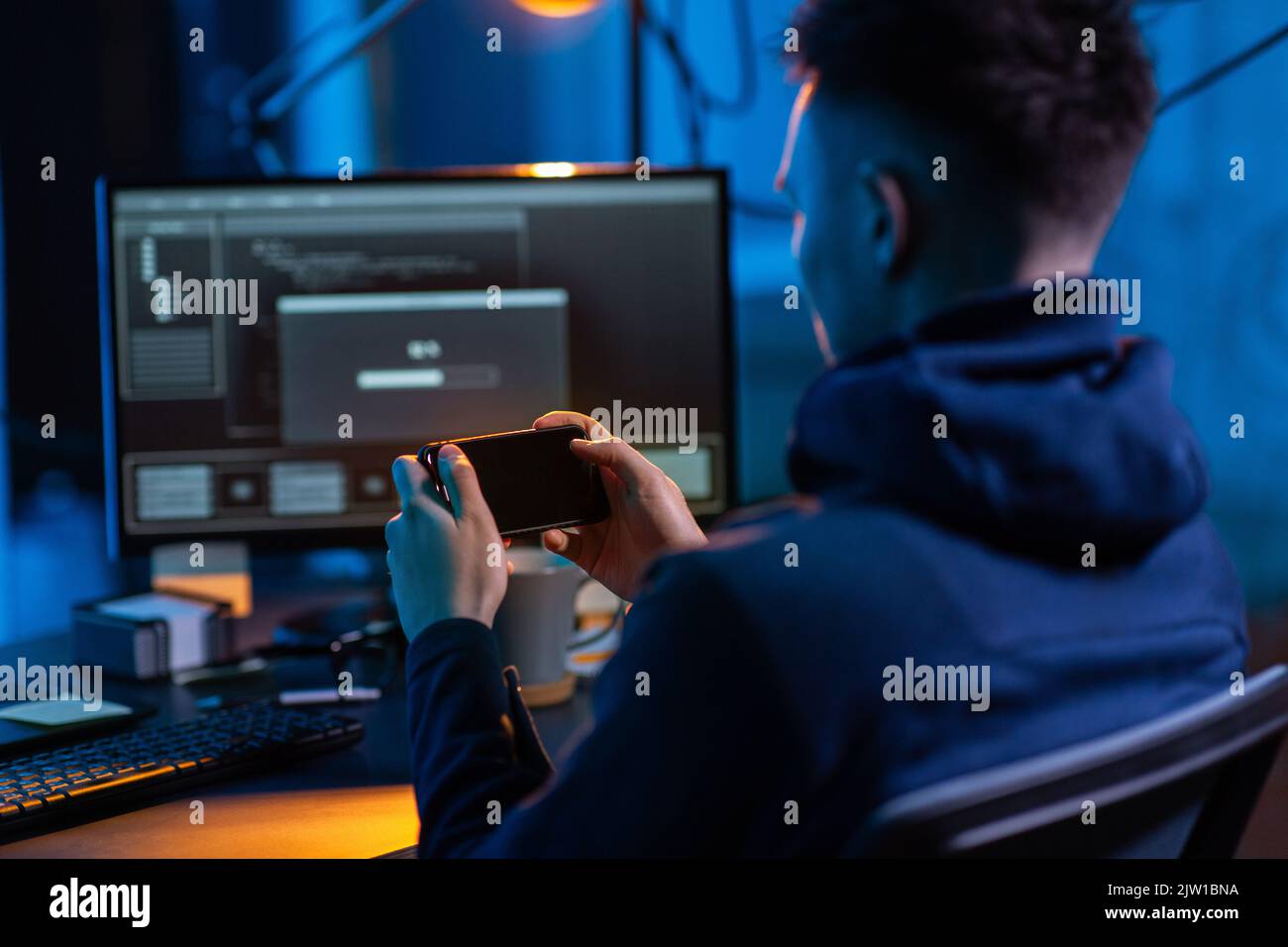 hacker with smartphone and computers in dark room Stock Photo - Alamy
