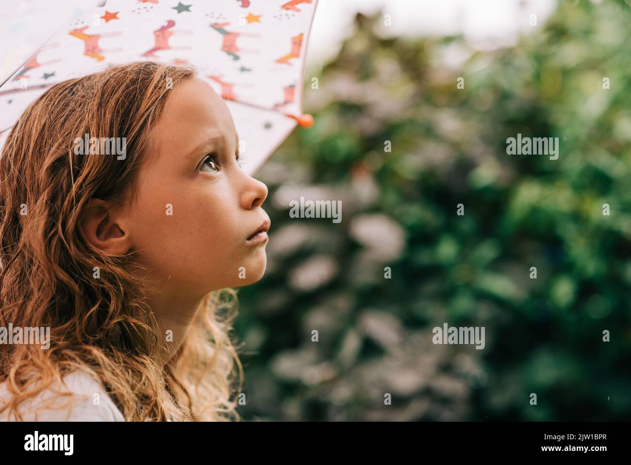 portrait of a girl holding an umbrella outside in the rain Stock Photo