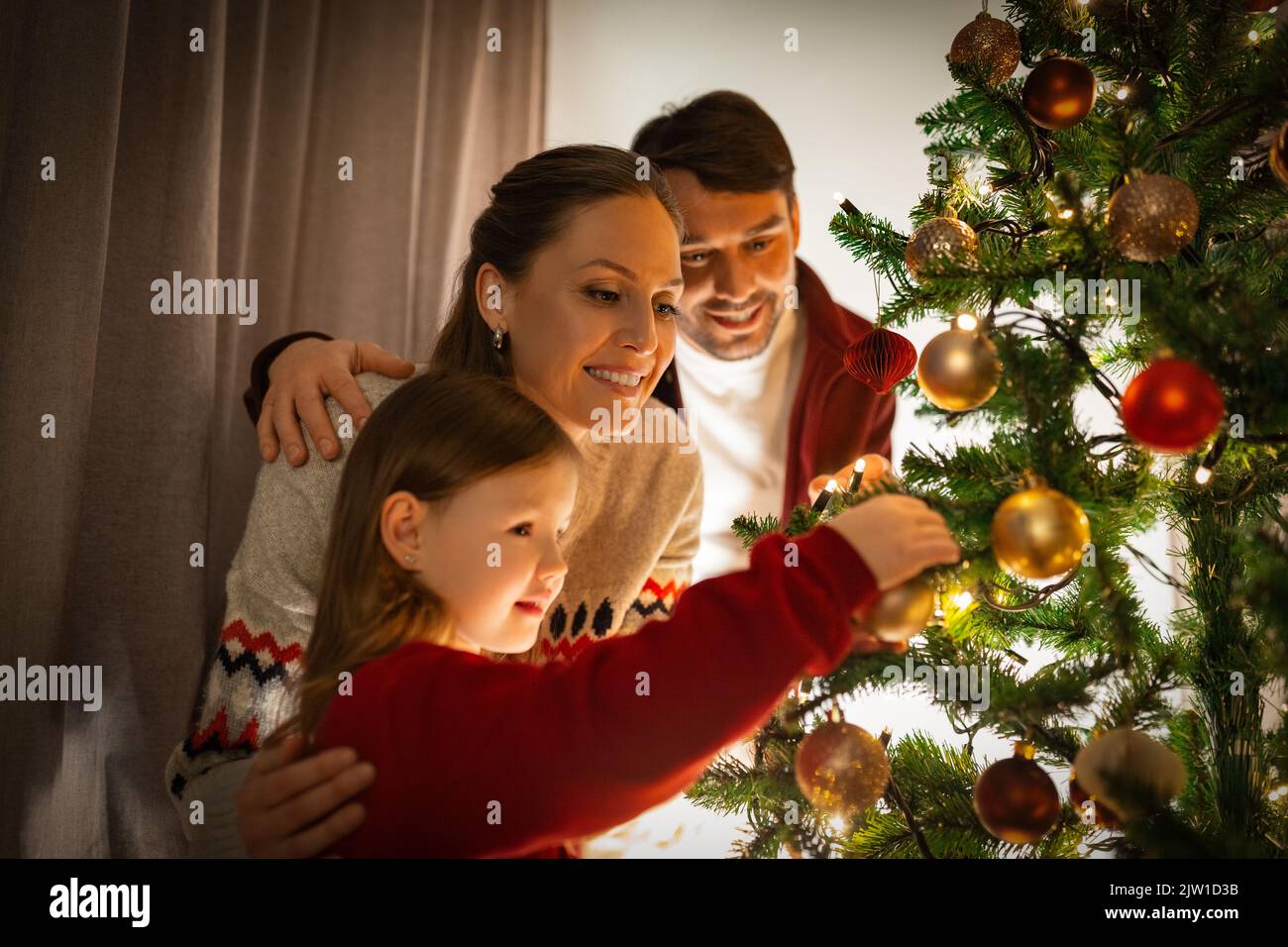 happy family decorating christmas tree at home Stock Photo - Alamy