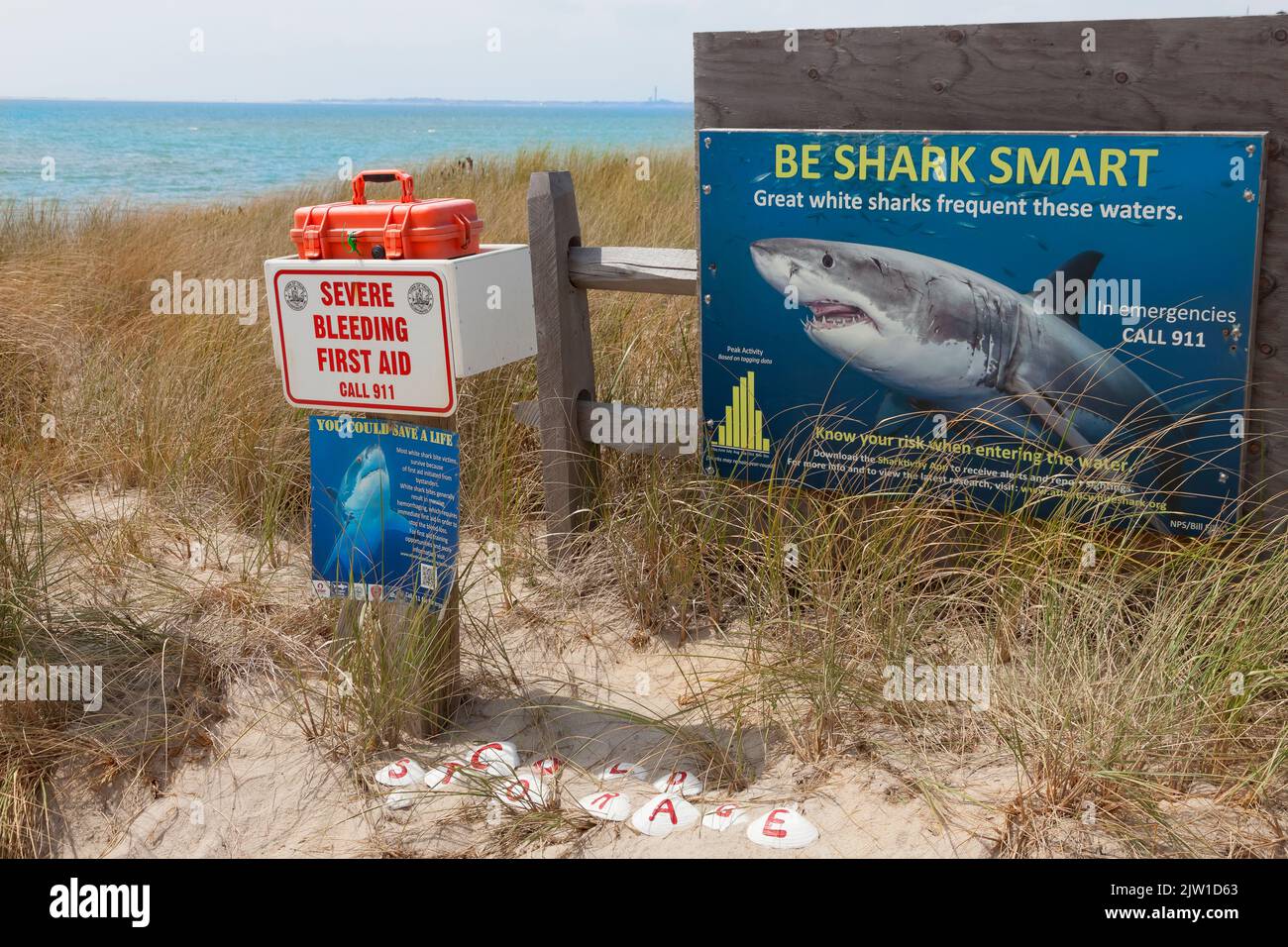 Shark warning sign & first aid kit at Cold Storage Beach, Truro, Barnstable County, Cape Cod, Massachusetts, United States. Stock Photo