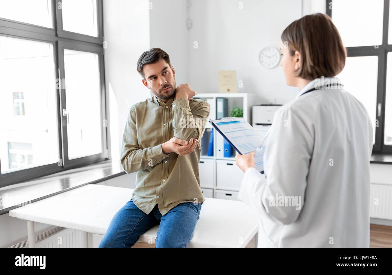 man patient showing sore arm to doctor at hospital Stock Photo Alamy