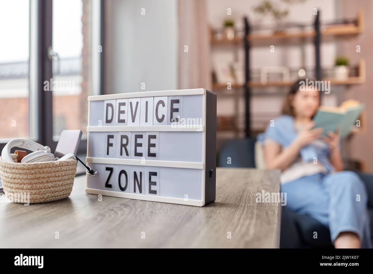 gadgets at device free zone and woman reading book Stock Photo - Alamy