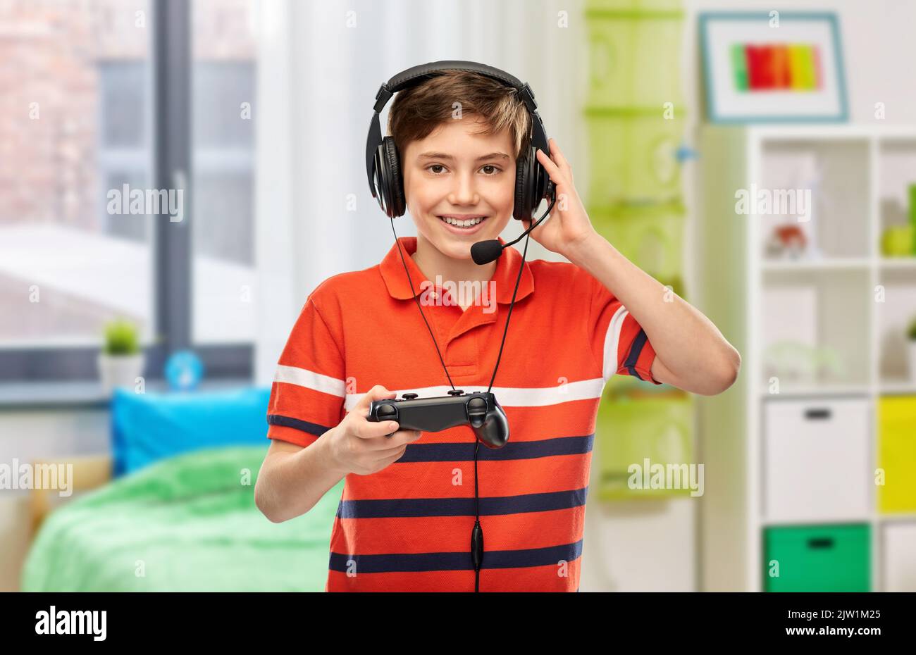 boy in headphones with gamepad playing video game Stock Photo - Alamy