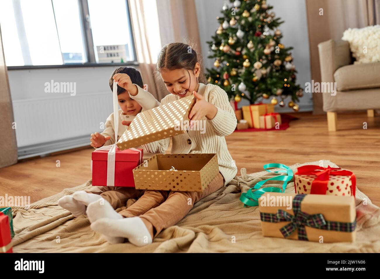 happy children opening christmas gifts at home Stock Photo