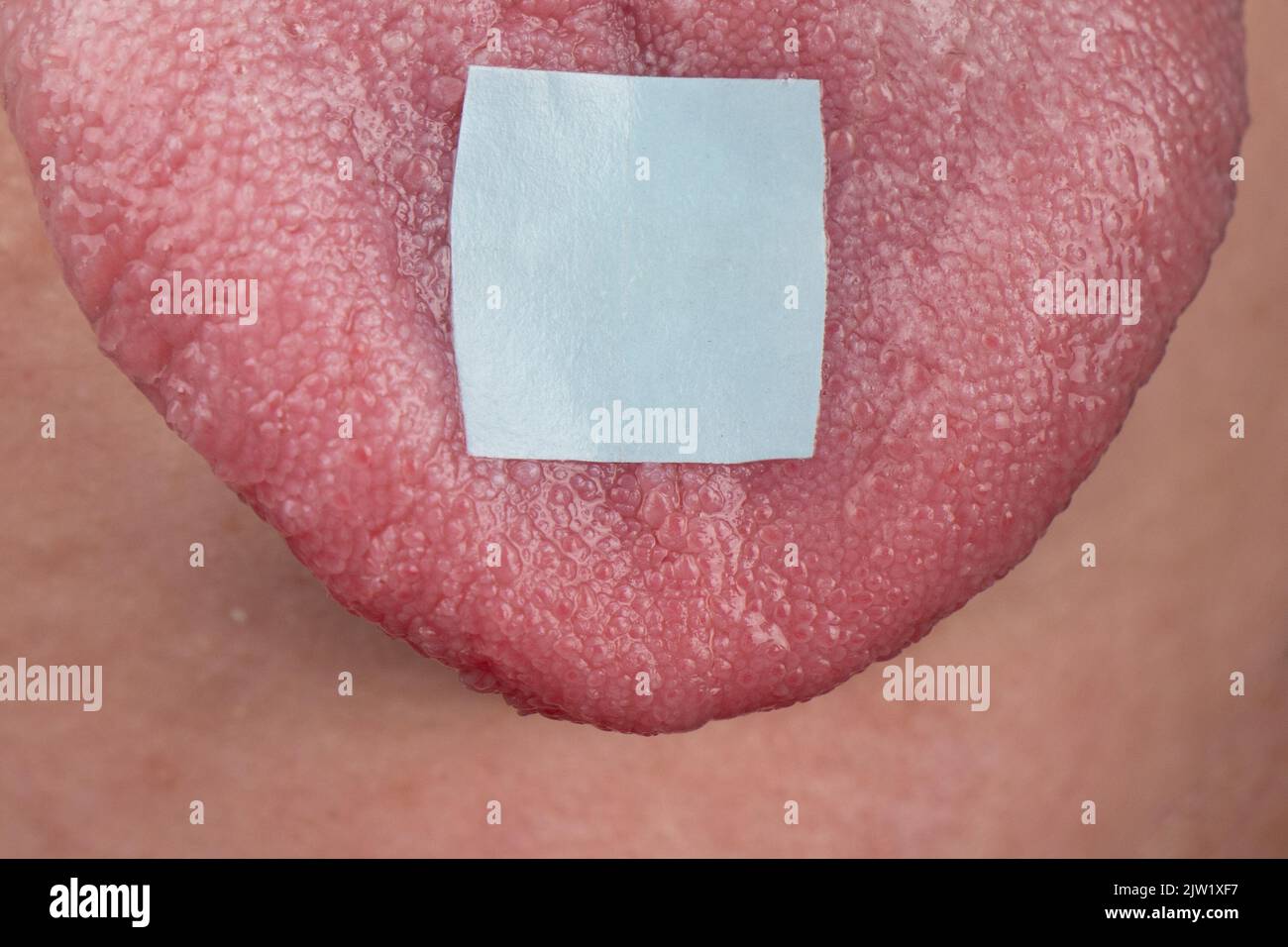 lsd mark on tongue closeup, psychedelic drug trip. Stock Photo