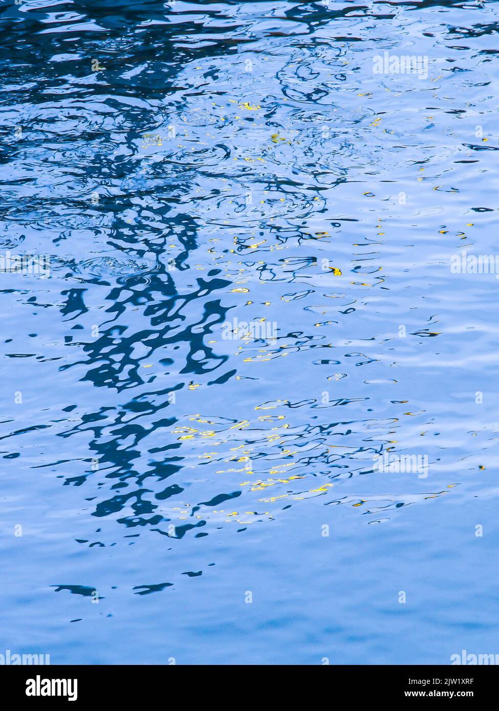 Ripples and light reflections on surface of blue water for background ...