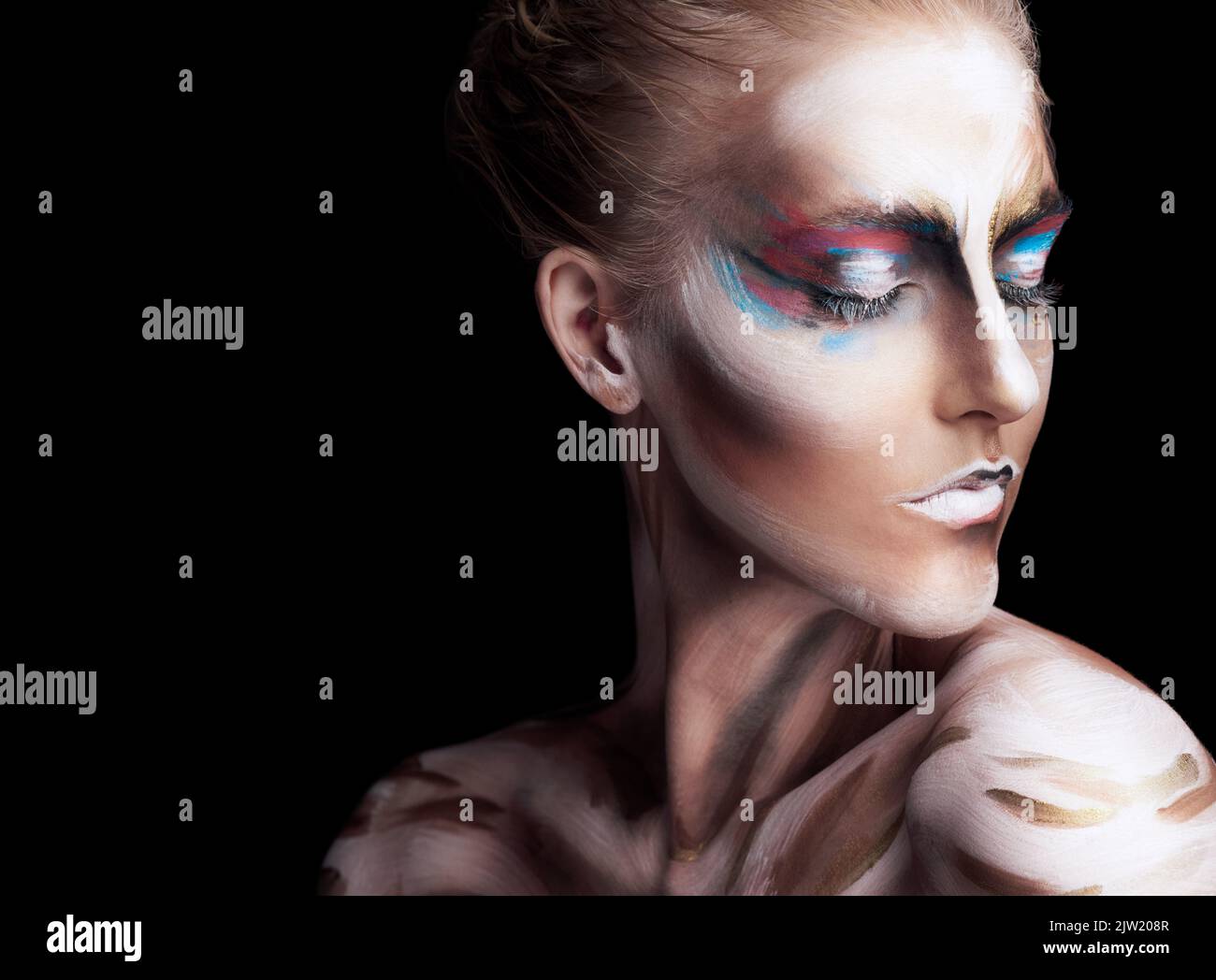 All ethereal. Studio shot of a young woman posing with paint on her face isolated on black. Stock Photo