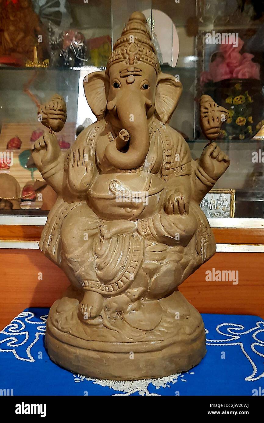 Installation of idol of environmental friendly unpainted, mud Ganesha for performing puja on Ganesha Chaturthi Day Stock Photo