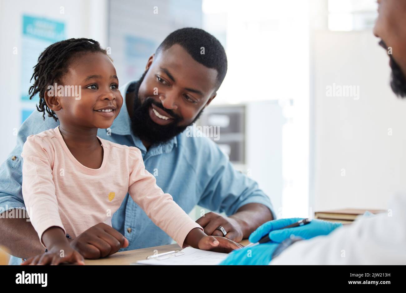 Doctor consultation with a black family, baby and father in a hospital or clinic office for healthcare, insurance and trust. Happy child in a checkup Stock Photo