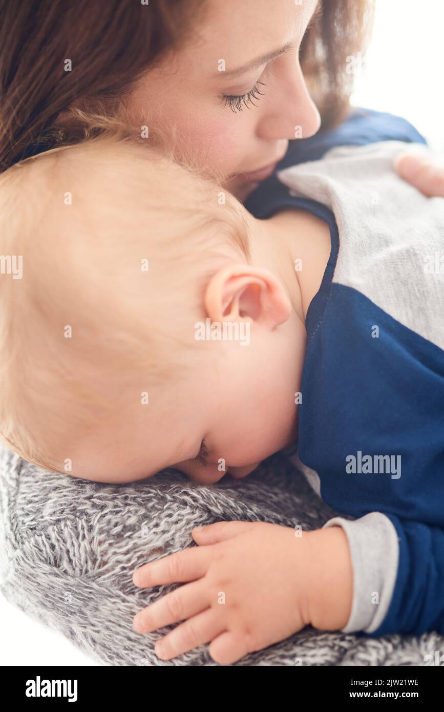 Holding on tight to her greatest joy. a mother holding her sleepy baby boy at home. Stock Photo