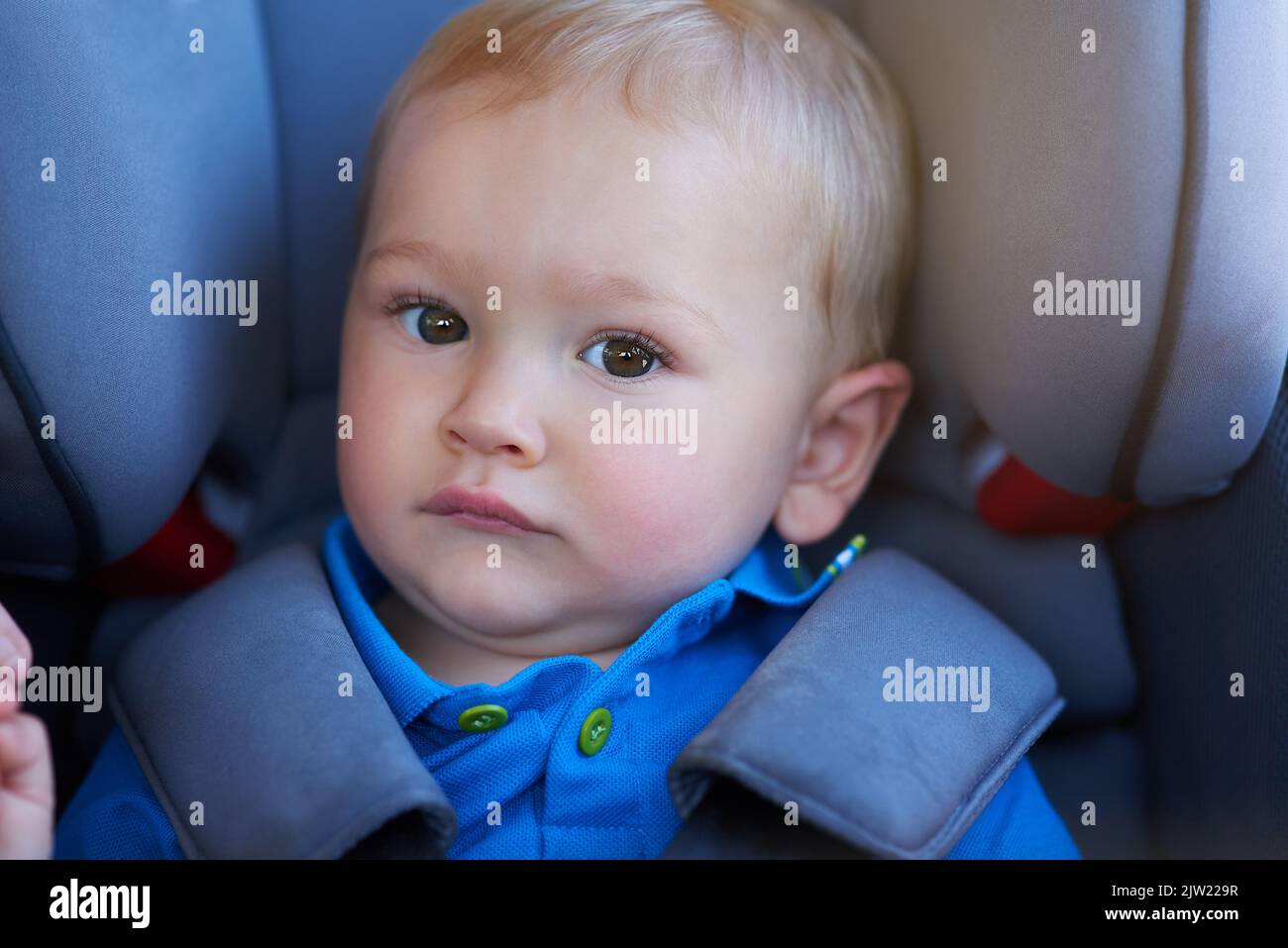 Baby sitting in a car in a car seat hires stock photography and images