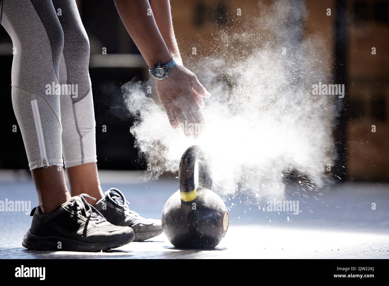 Woman powder hands, kettlebell fitness and ready for gym training, workout and exercise in healthy club. Bodybuilder athlete with power, dust and Stock Photo