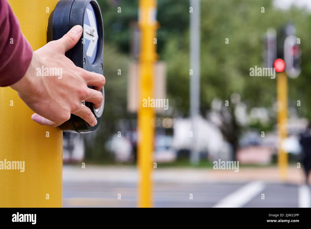 Always cross with care. a mans hand pressing the crossing button at an ...