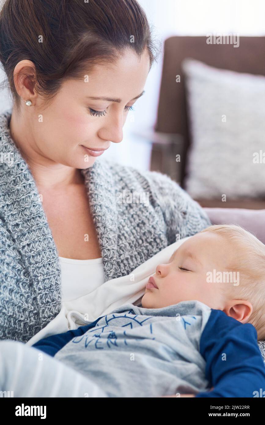 He fills my heart with so much love. a mother holding her sleepy baby boy at home. Stock Photo