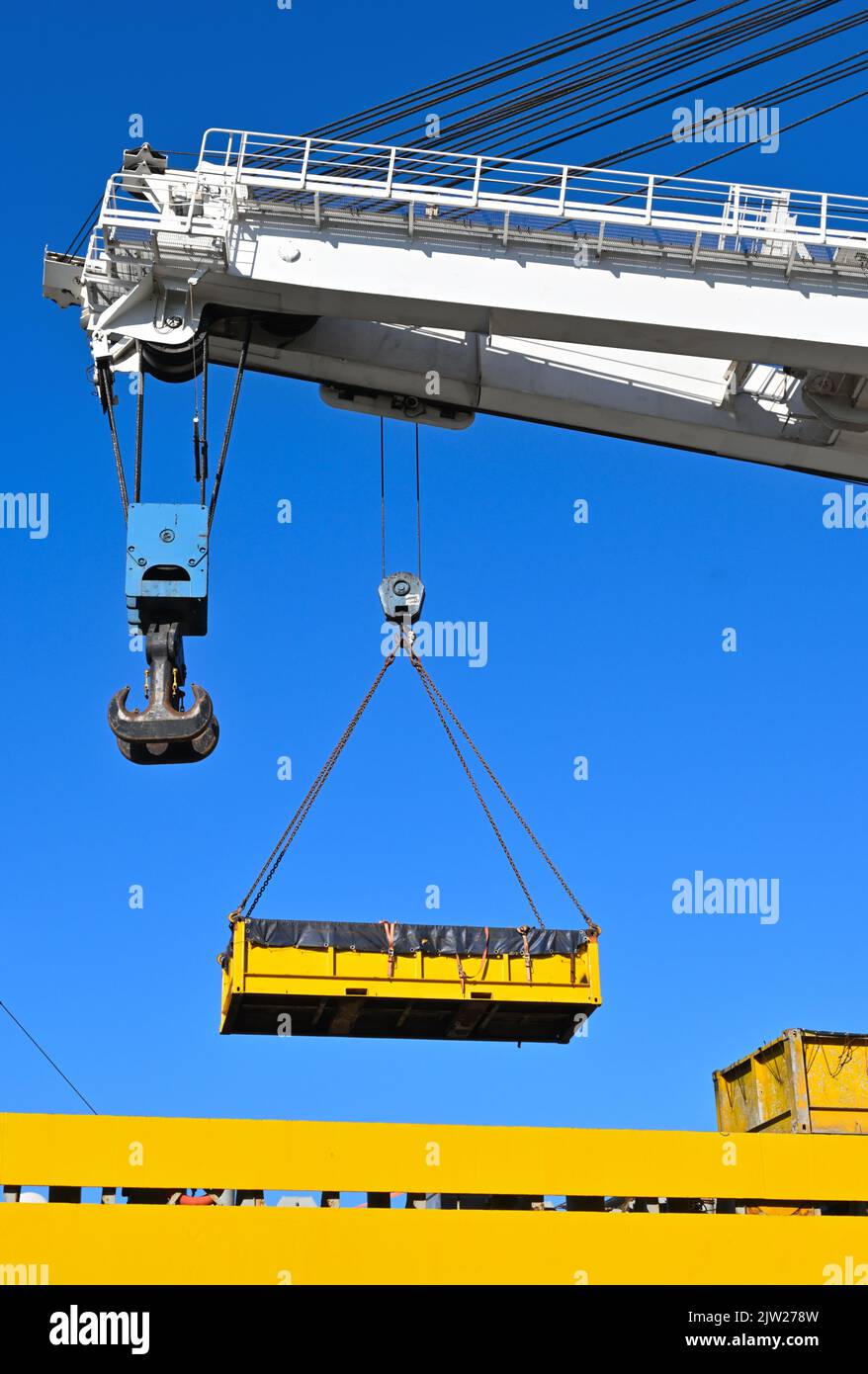 Yellow outdoor crane used in ship industry, electric overhead traveling crane above the vessel Stock Photo
