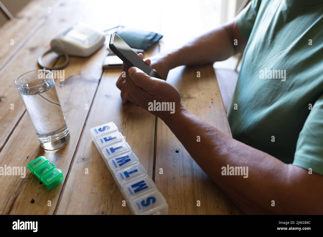 Senior african american man sitting by table using smartphone Stock Photo