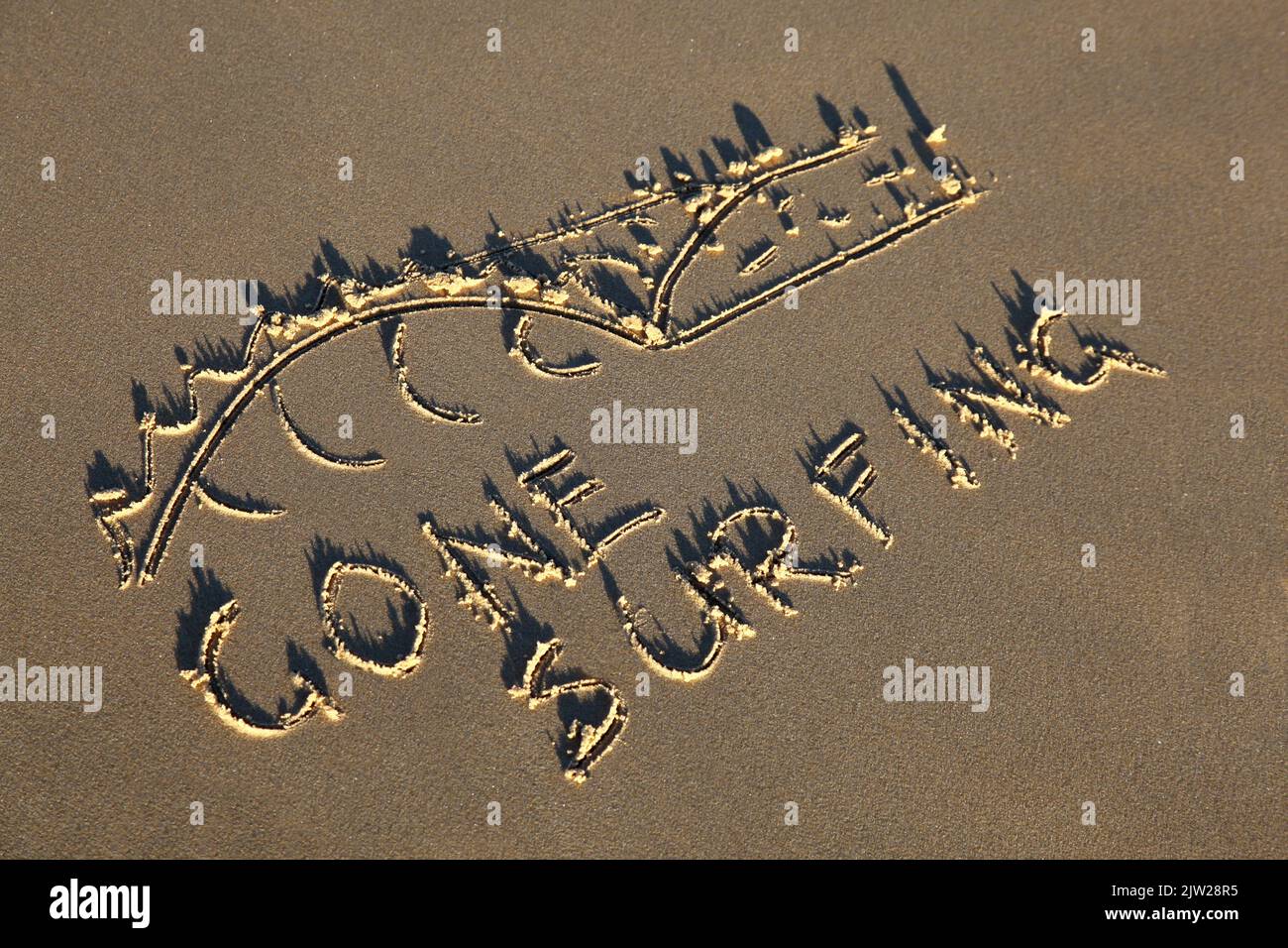 Gone surfing and wave drawn in the sand. Summer beach concept Stock Photo