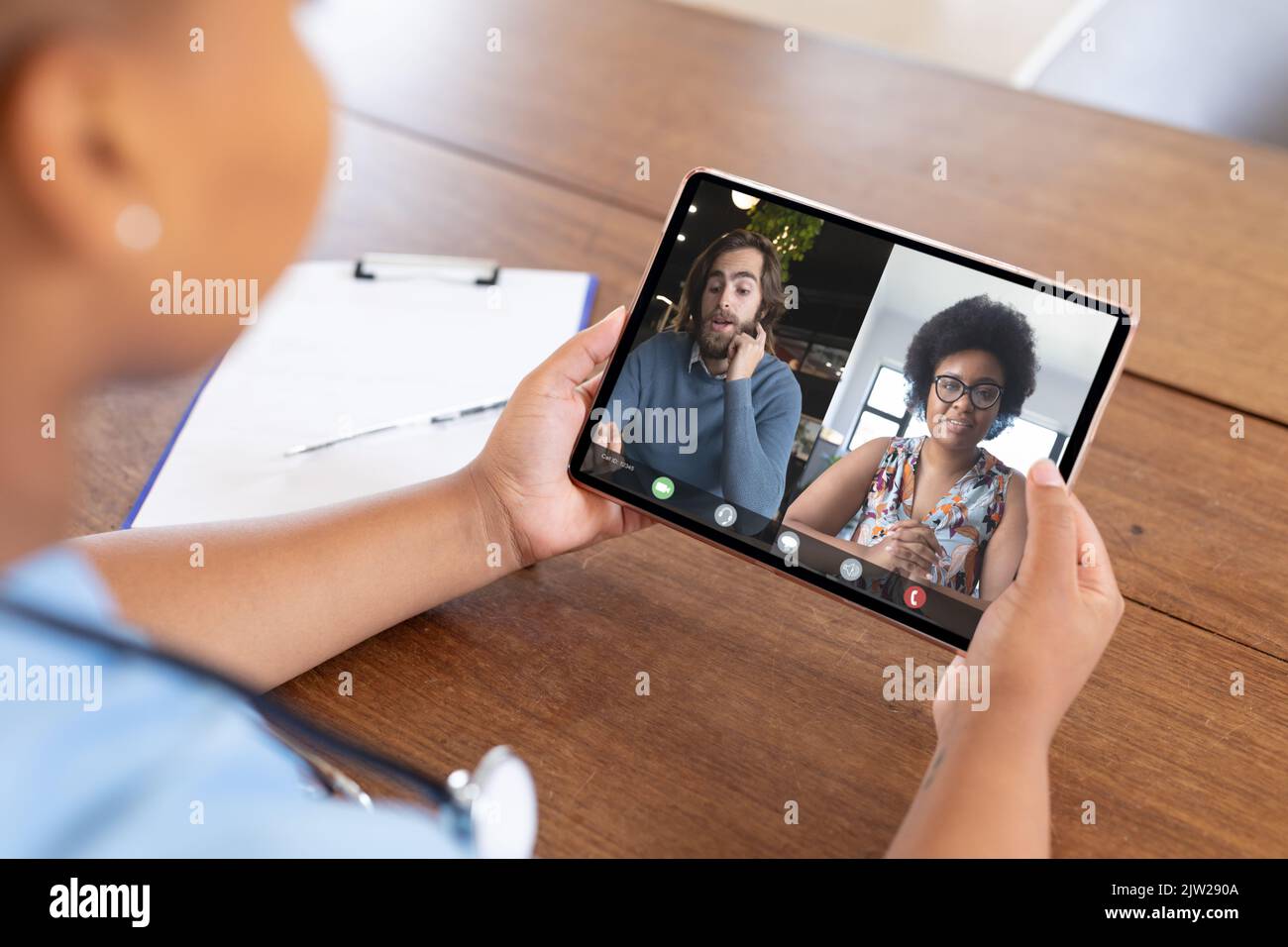 Multiracial man and woman during video conference with african american female doctor Stock Photo