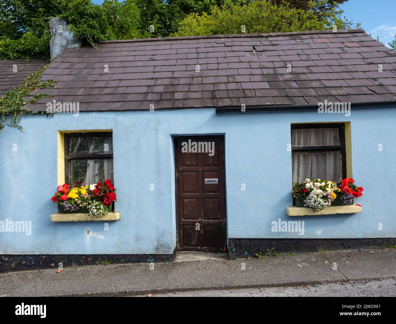 A blue traditional cottage in a street in Cong, on the border of County Galway and County Mayo in Ireland. Stock Photo
