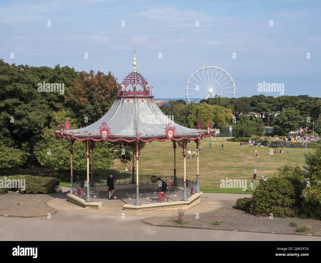 The Bandstand in South Shields South Marine Park with the seaside Ferris wheel in the background, England, UK Stock Photo