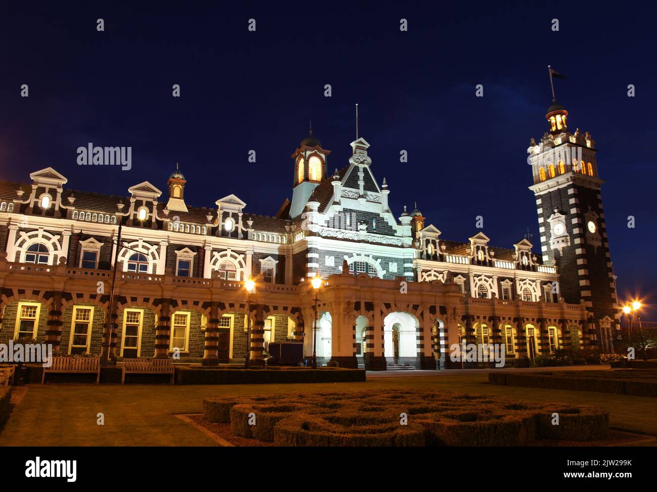 Dunedin's famous historic railway station at nightime. - Dunedin New Zealand. This ornate Flemish Renaissance-style building was opened in 1906 and is Stock Photo