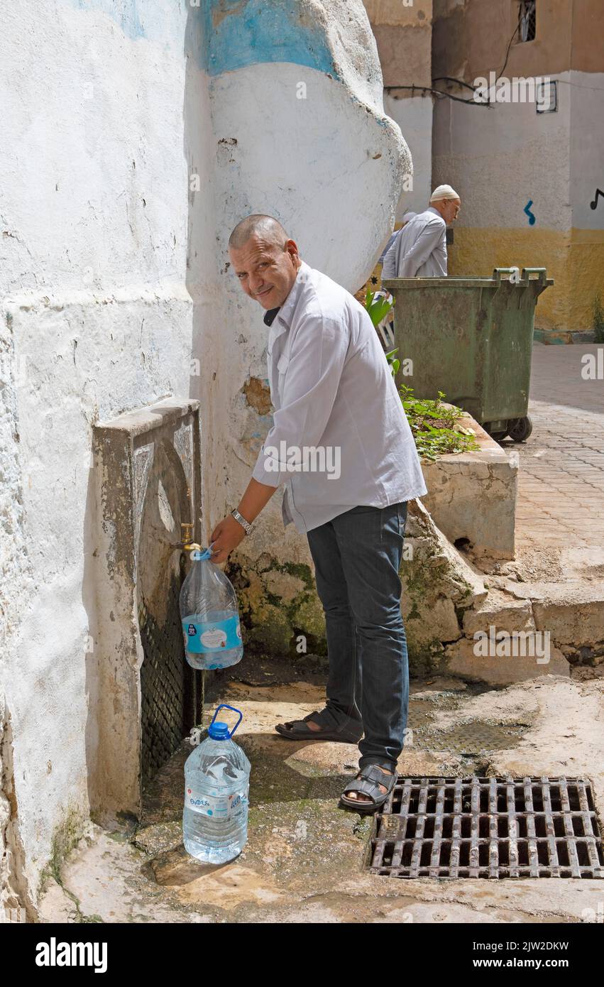 Moroccan man fetching drinking water at a standpipe, Old Town, Fez