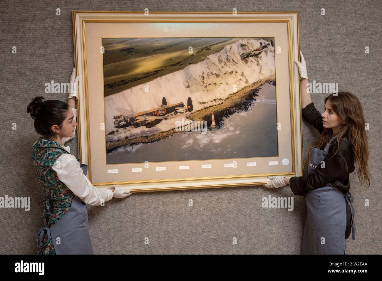 PHOTO:JEFF GILBERT 25th August 2022, London, UK Bonhams gallery staff hold a lenticular annimation picture being auctioned by 617 Squadran Dambusters Stock Photo