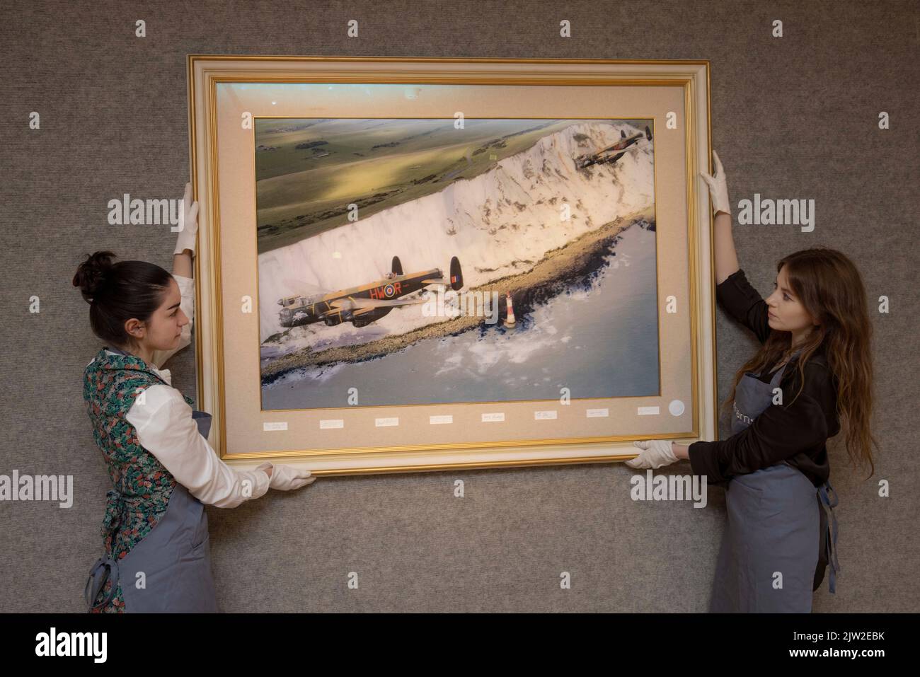 PHOTO:JEFF GILBERT 25th August 2022, London, UK Bonhams gallery staff hold a lenticular annimation picture being auctioned by 617 Squadran Dambusters Stock Photo
