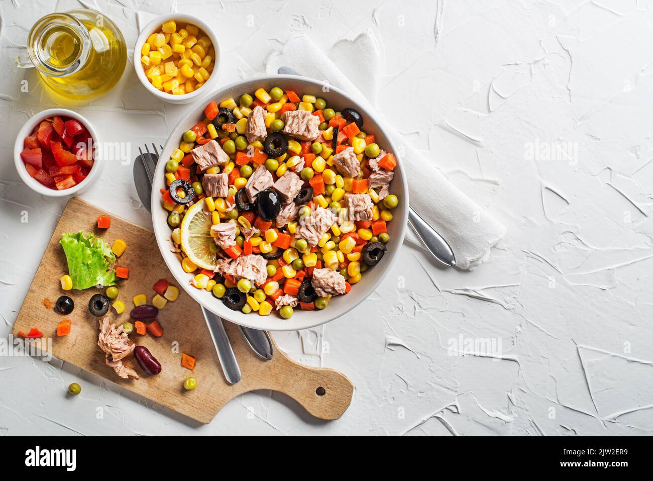 Healthy tuna salad with corns, carrots, peas, peppers and olives on