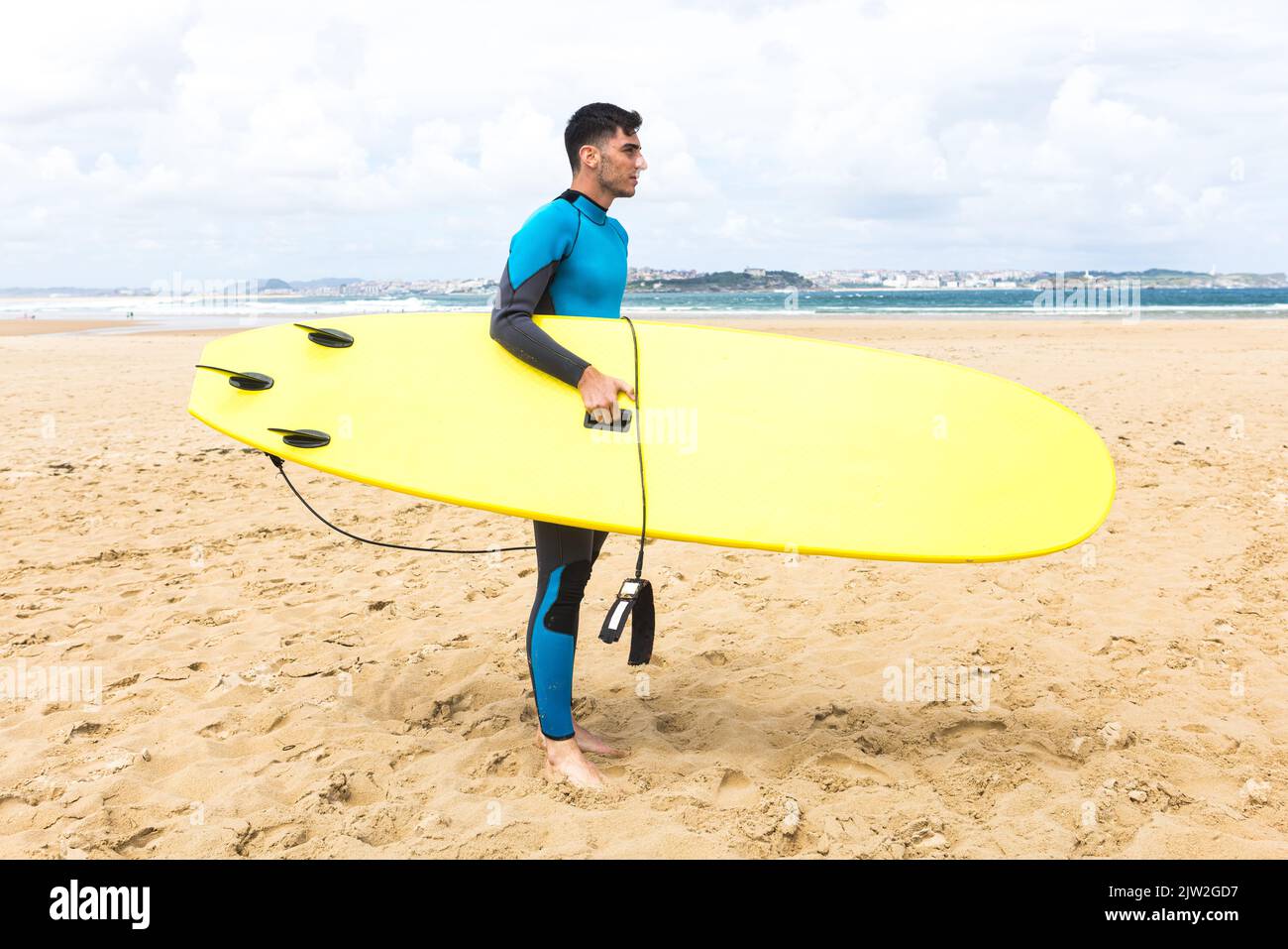 Side view full body of thoughtful young Hispanic male surfer with dark ...