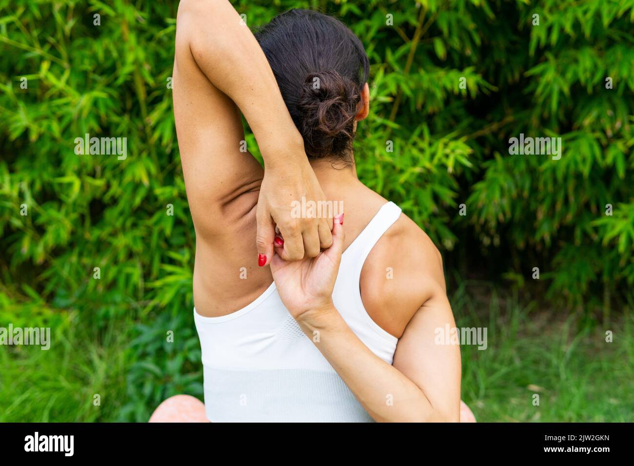 Lock Behind Back view of anonymous active female making hands lock behind back ...