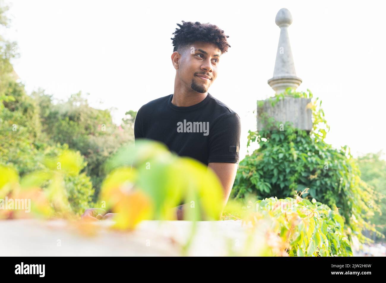 Confident young man looking away while standing against sky Stock Photo