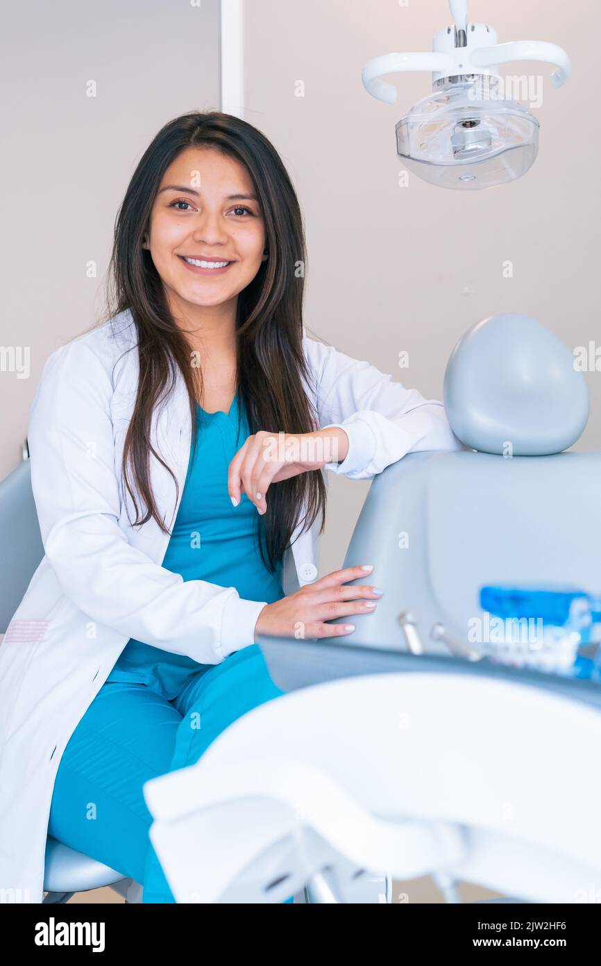 Content young Hispanic female dentist with long dark hair in medical
