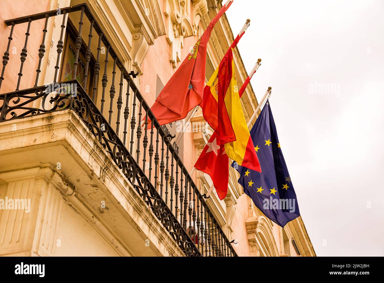 Spanish flag flanked by that of the city of Alcala of Henares, the province of Madrid and Europe Stock Photo