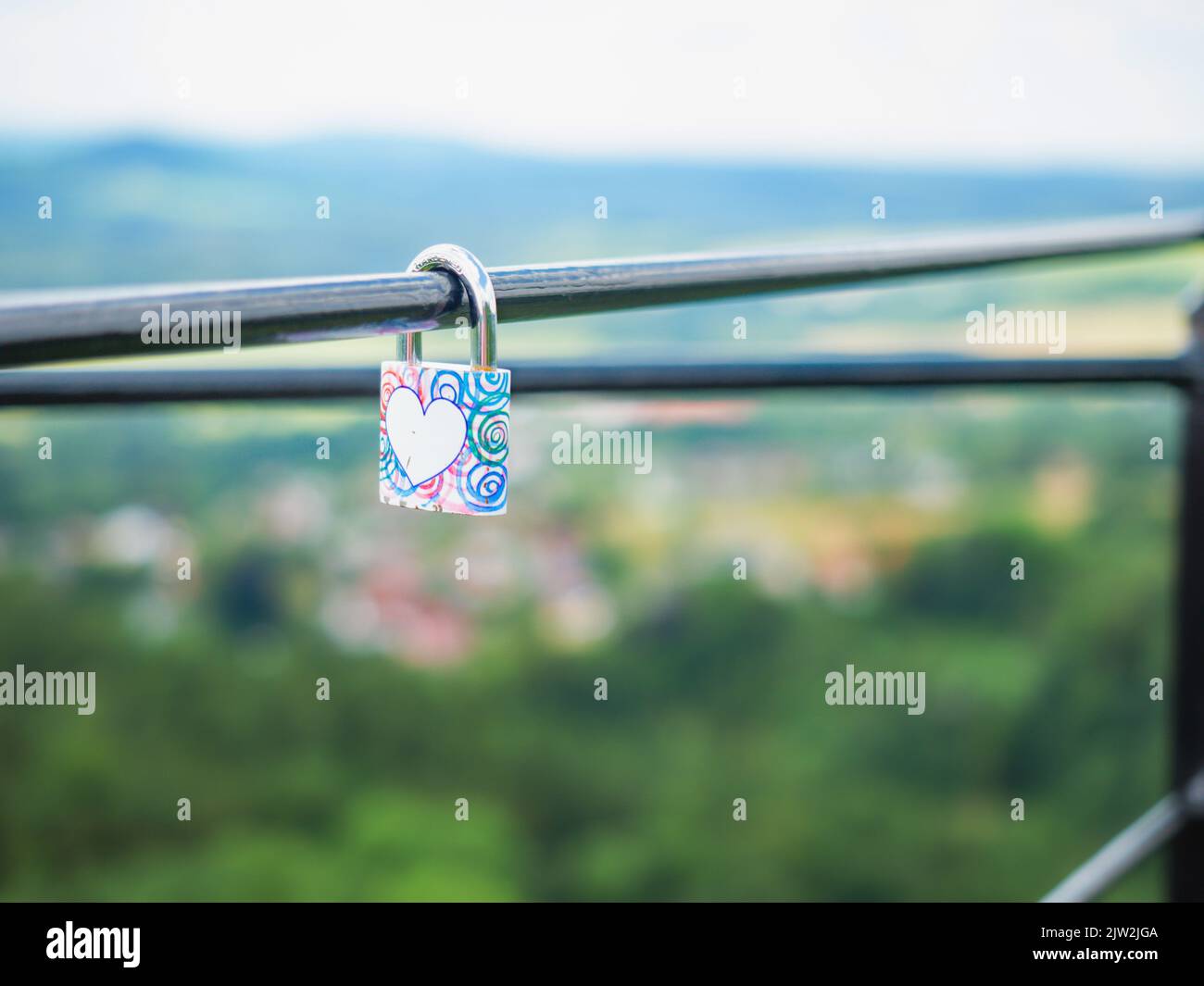 Locked lock hangs on the metal fence. Symbol of love in the park. The