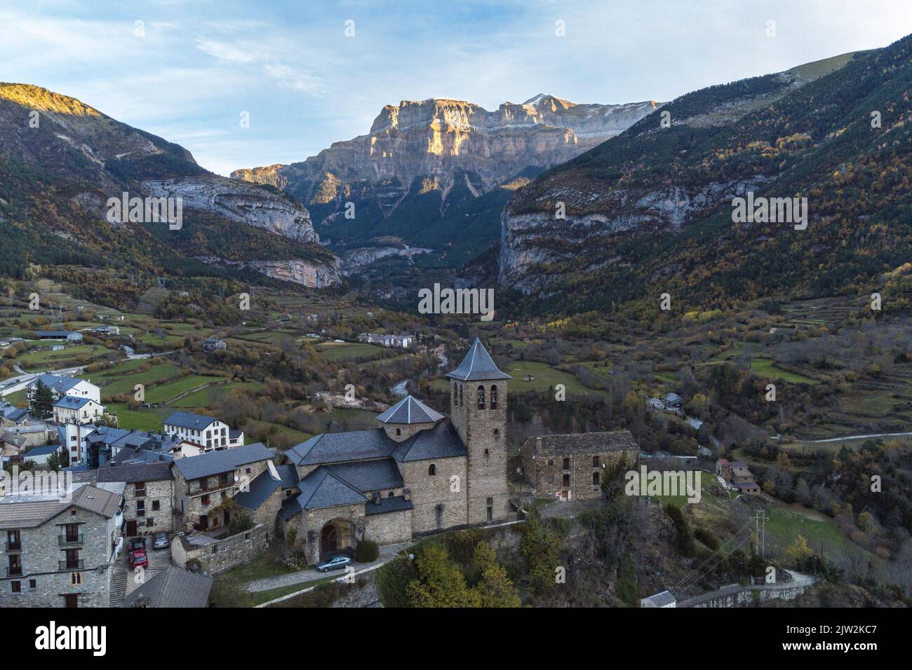 Picturesque drone view of ancient stone castle and residential houses surrounded by massive rocky mountains in Torla Ordesa town in Huesca Stock Photo