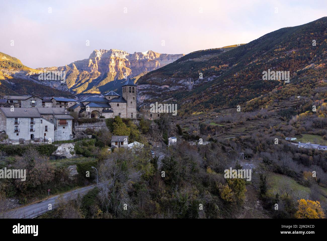 Picturesque drone view of ancient stone castle and residential houses surrounded by massive rocky mountains in Torla Ordesa town in Huesca Stock Photo