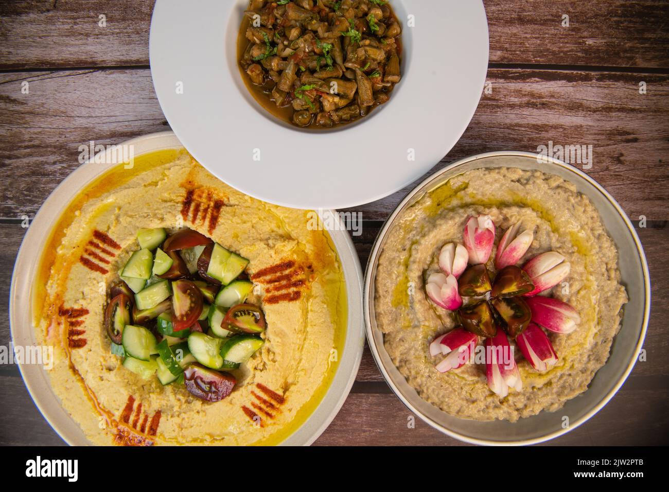 Lebanese meze, hummus, aubergine caviar and okra in tomato sauce Stock Photo