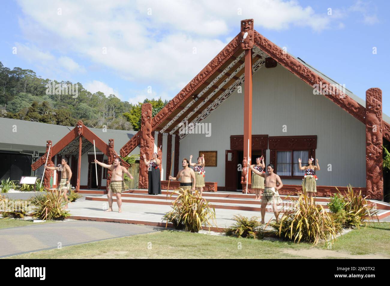 A group of Tamaki Maori dancers perform their traditional ceremony dance, Haka for the benefit of visitors in front of the Wharenui (Maori Meeting hou Stock Photo