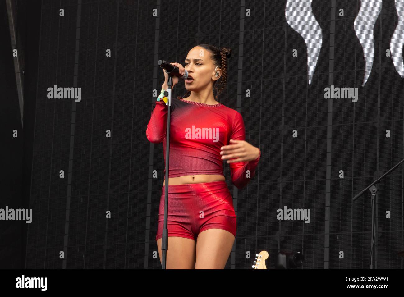 Maeve singing wearing a red top and shorts Stock Photo