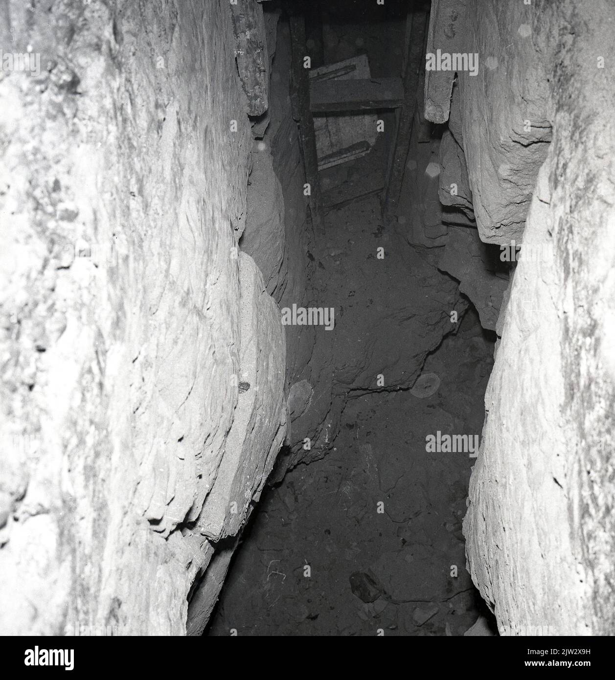 1960s, historical, inside a disused mine shaft, showing wooden ladder/steps at the bottom of the shaft leading to the narrow tunnel at the old coal-mining village of Townshill, Fife, Scotland, UK. Stock Photo