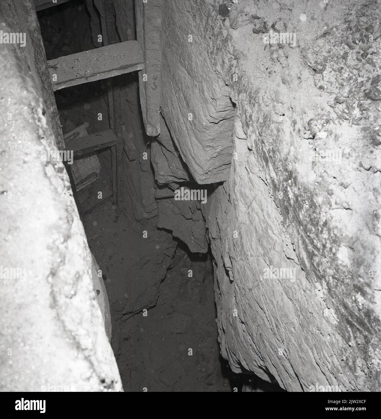 1960s, historical, an old, disused mine shaft, showing wooden ladder or steps down to the narrow underground tunnel, Townshill, Fife, Scotland, UK. Stock Photo