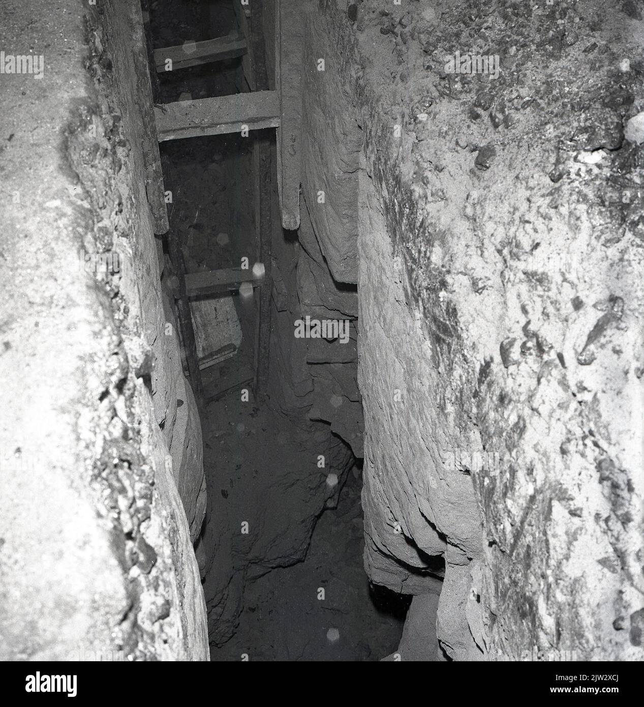 1960s, historical, disused mine shaft, showing wooden ladder down to the narrow tunnel, in the old coal mining village of Townshill, Fife, Scotland, UK. Stock Photo