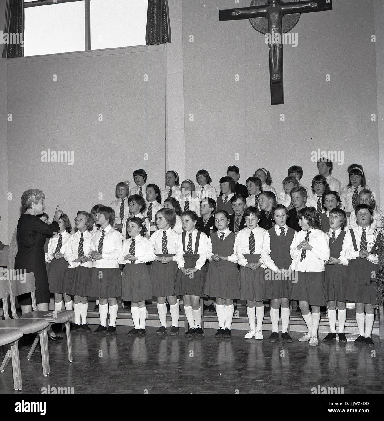 1965, historical, a group of young children standing singing hymns in the school hall of the Roman Catholic (RC) school, St Kenneth's Primary school in the old mining village of Ballingry, Scotland, UK Stock Photo