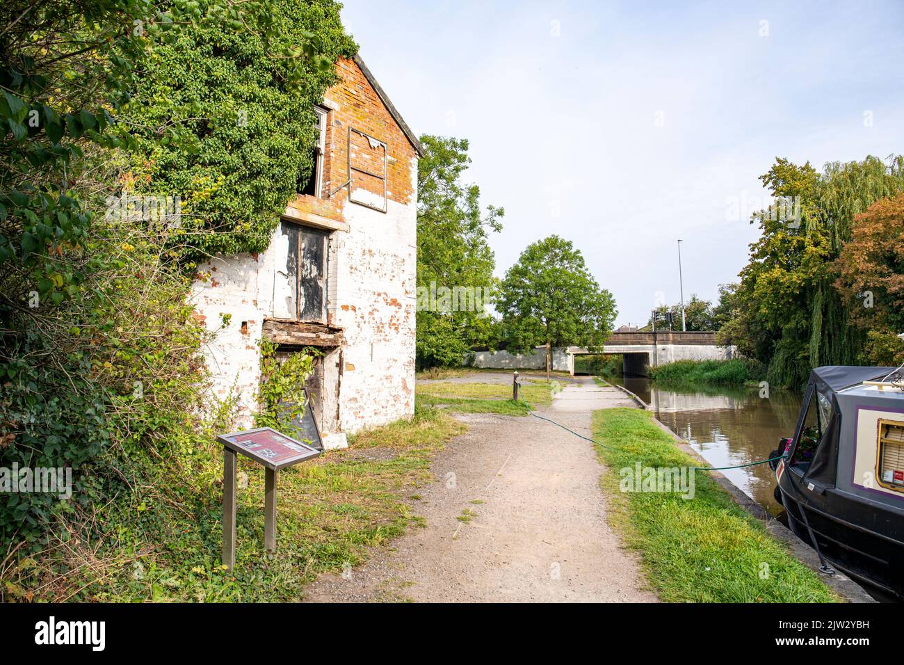 Towpath with derelict canal cottage on the Trent and Mersey canal in Middlewich Cheshire UK Stock Photo