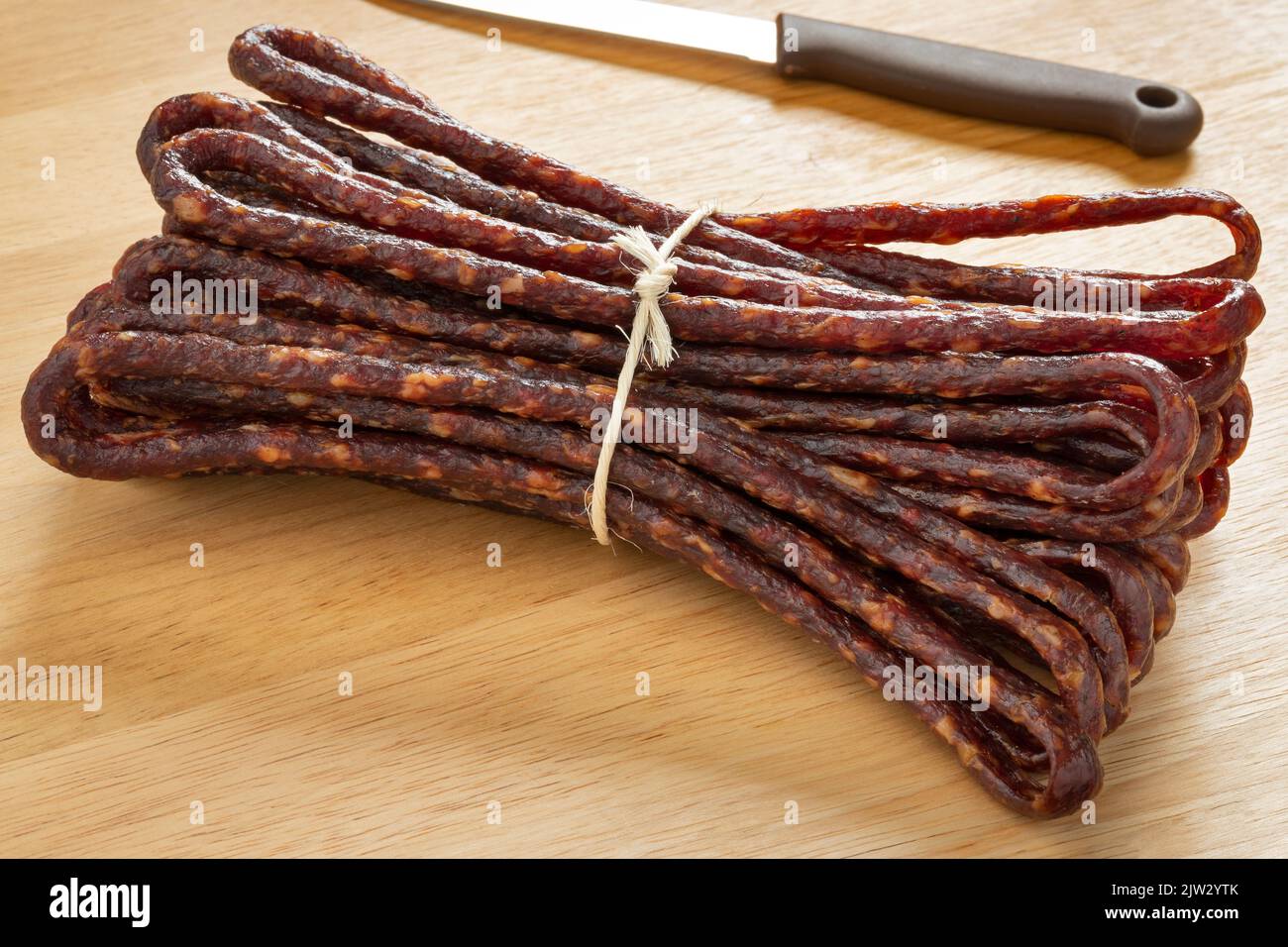 Traditional bunch of Croatian dry sausage, mini Kobasica, on a cutting board close up Stock Photo