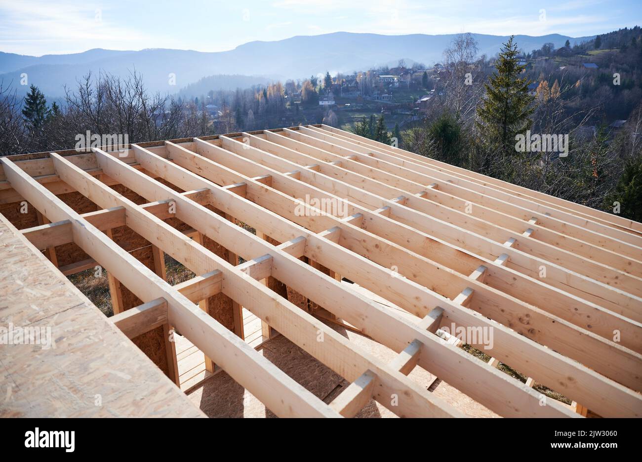Aerial view roof of wooden frame house under construction in the mountains. Stock Photo