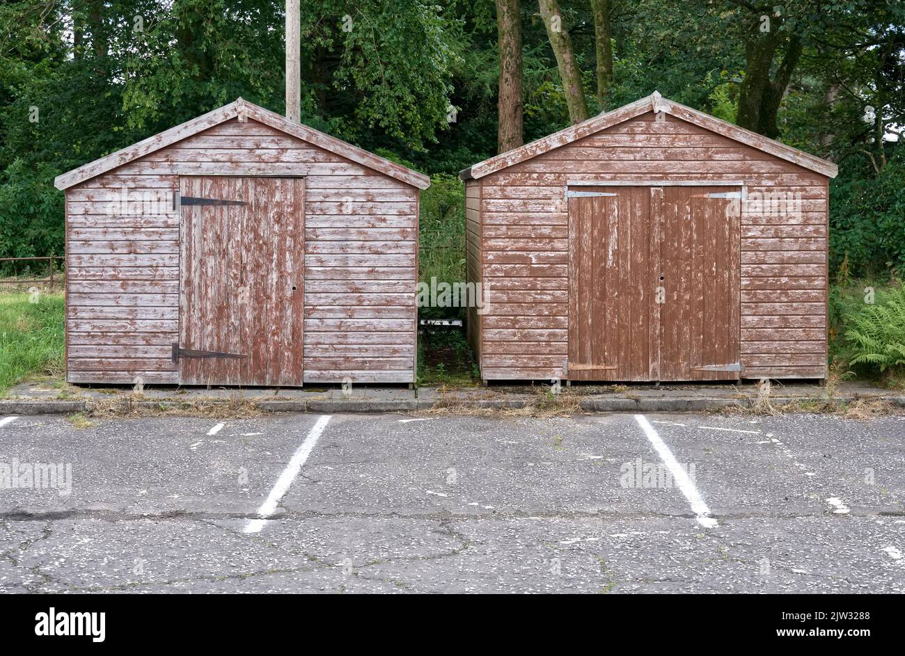 Brown wood sheds in rural countryside car park Stock Photo